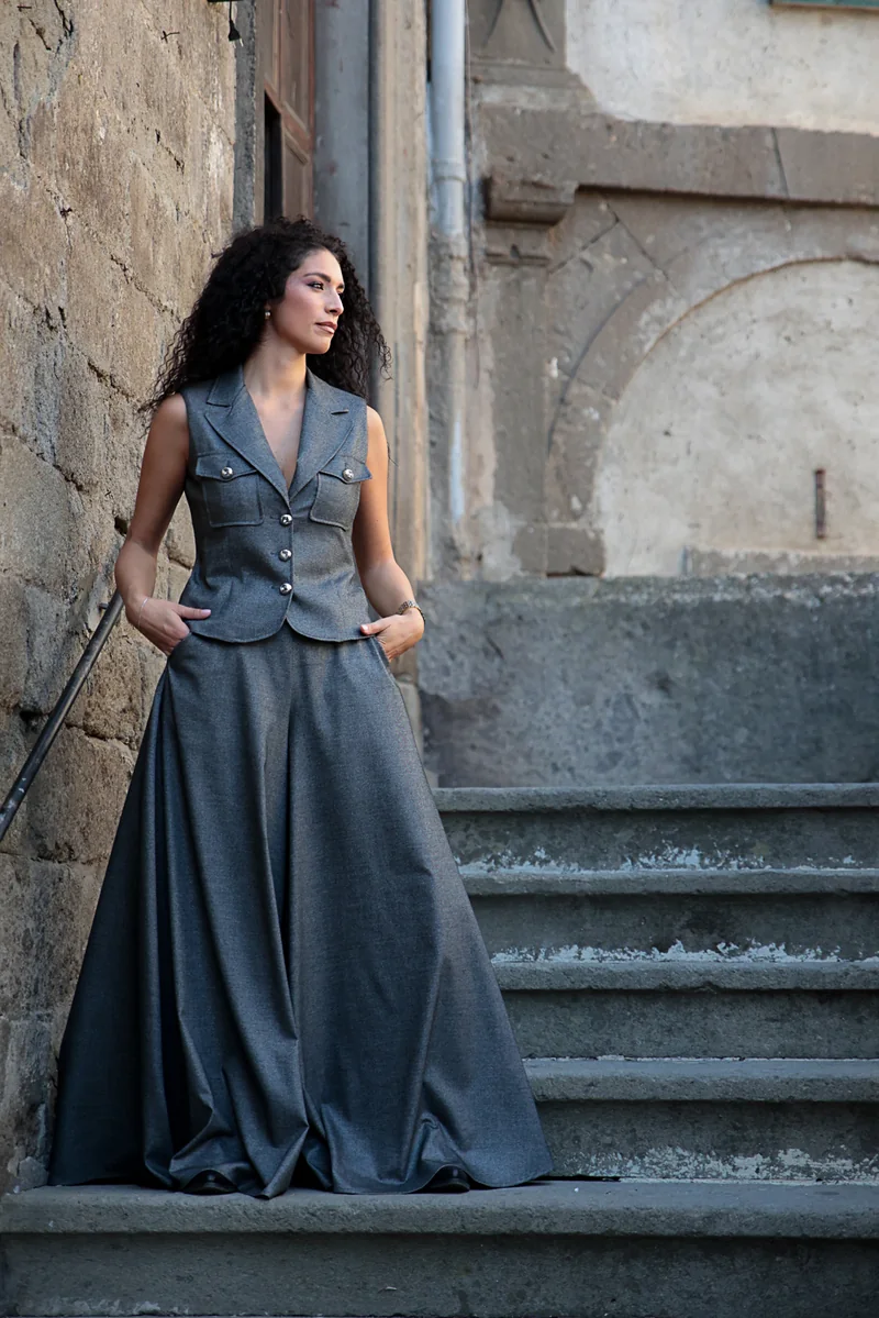 Completo grigio con gilet e pantaloni ampi sulle scale di Bagnaia